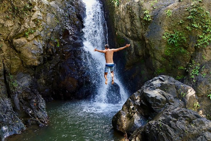 Natural rock waterslide in El Yunque rainforest with person sliding down